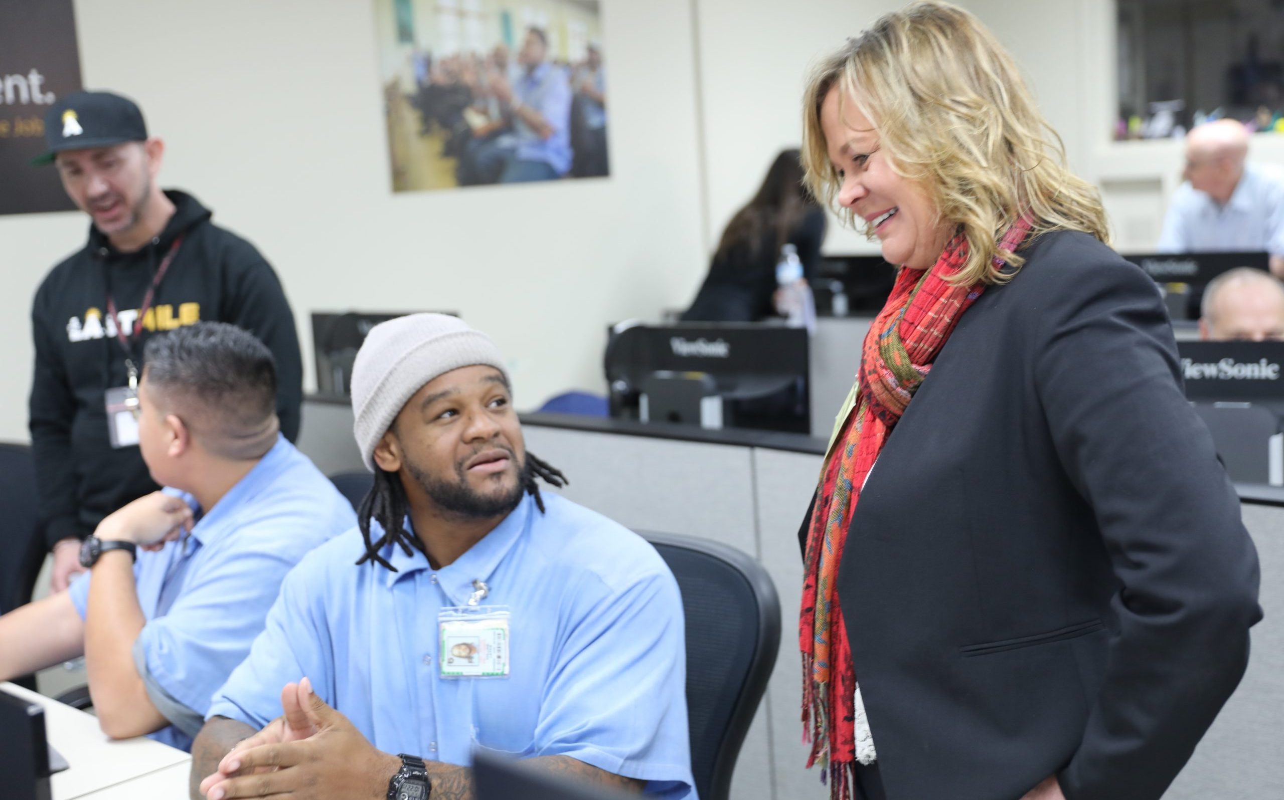 A woman speaks with a student enrolled in The Last Mile computing coding CALPIA program at San Quentin Rehabilitation Center.