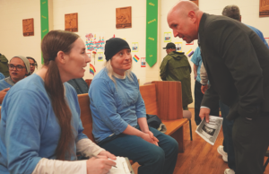 San Quentin warden speaks with two incarcerated people at the second Transgender Day of Remembrance.