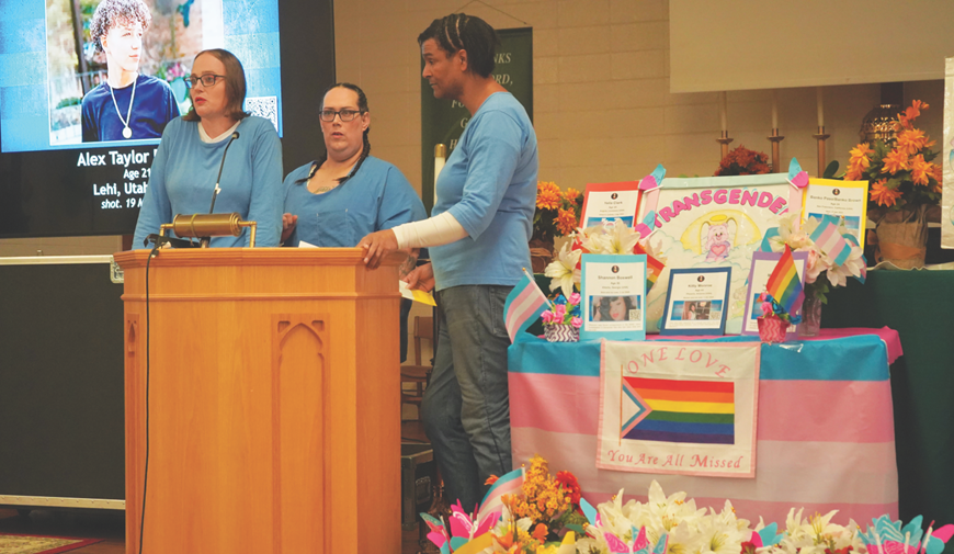 Three incarcerated individuals stand at a lectern during the event at San Quentin.