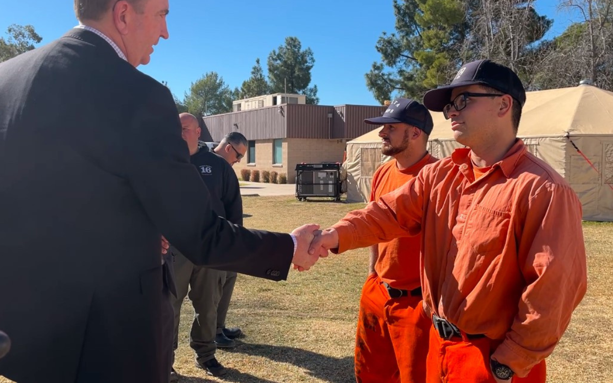 Secretary Macomber shakes hands with an incarcerated fire crew member at Holton Conservation Camp.