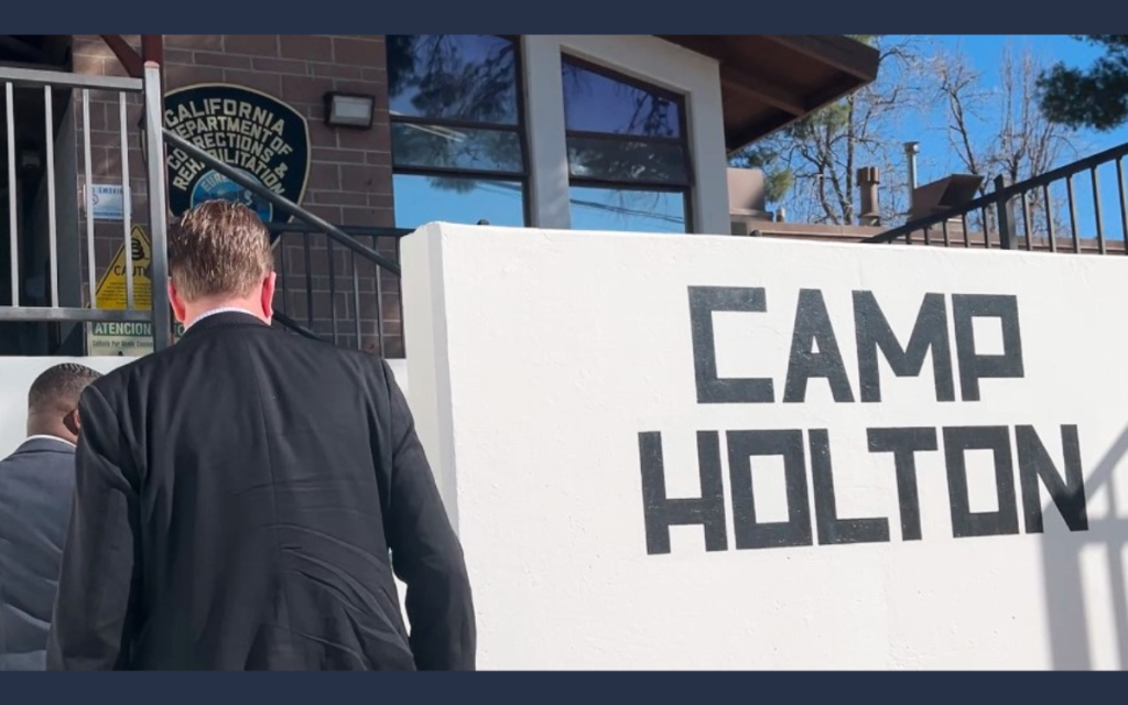 Secretary and another person walk into Holton Conservation Camp.