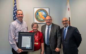 Group photo with CDCR secretary and three people with resolution showing support for Special Olympics resolution.