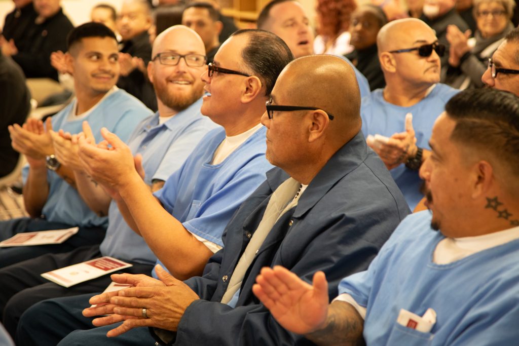 Incarcerated people applaud during a graduation ceremony at CSP-Corcoran.