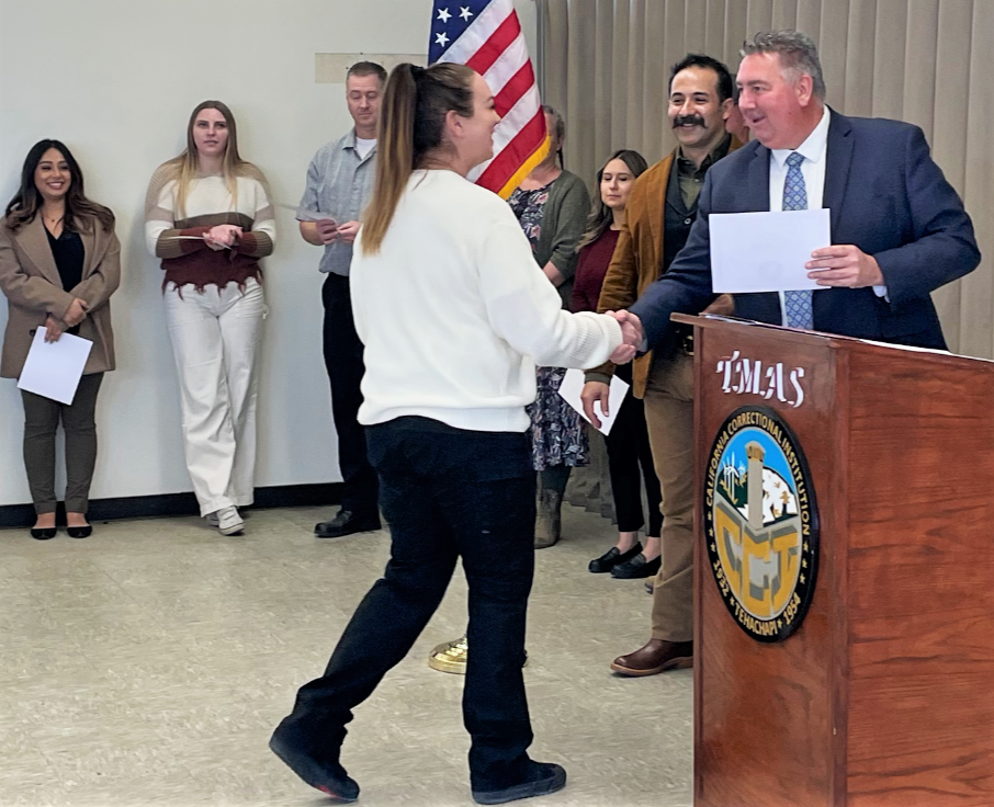 A case records analyst receives recognition on her promotion.