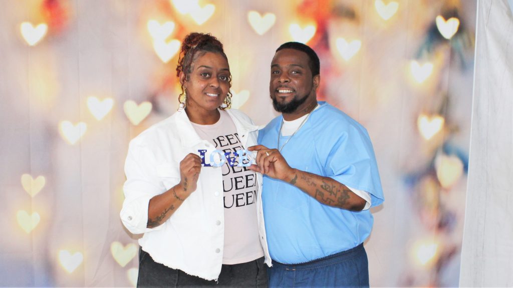 Man and woman hold a sign with the word "love."