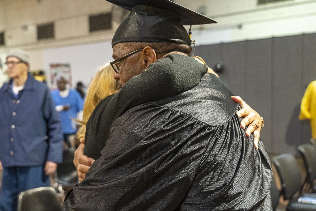 Hug for a loved one as after 55 incarcerated students accepted education degrees and diplomas at CIM.