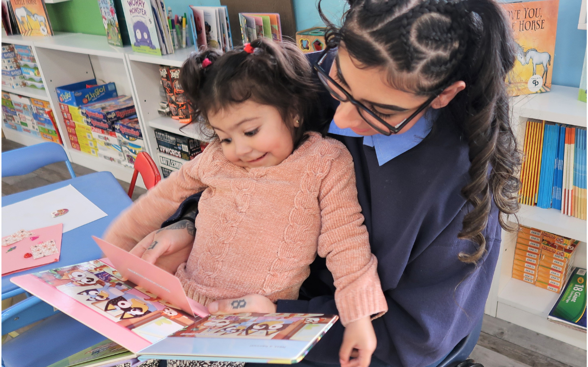 CIW read to your child day shows moms and kids bonding over books, such as this one mother with her young child sitting on lap.