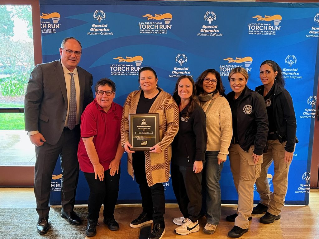 Multiple people standing in front of the torch run banner