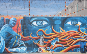 Murals a California State Prison, Los Angeles County, with tentacles, eyes, buildings, and barbed wire.