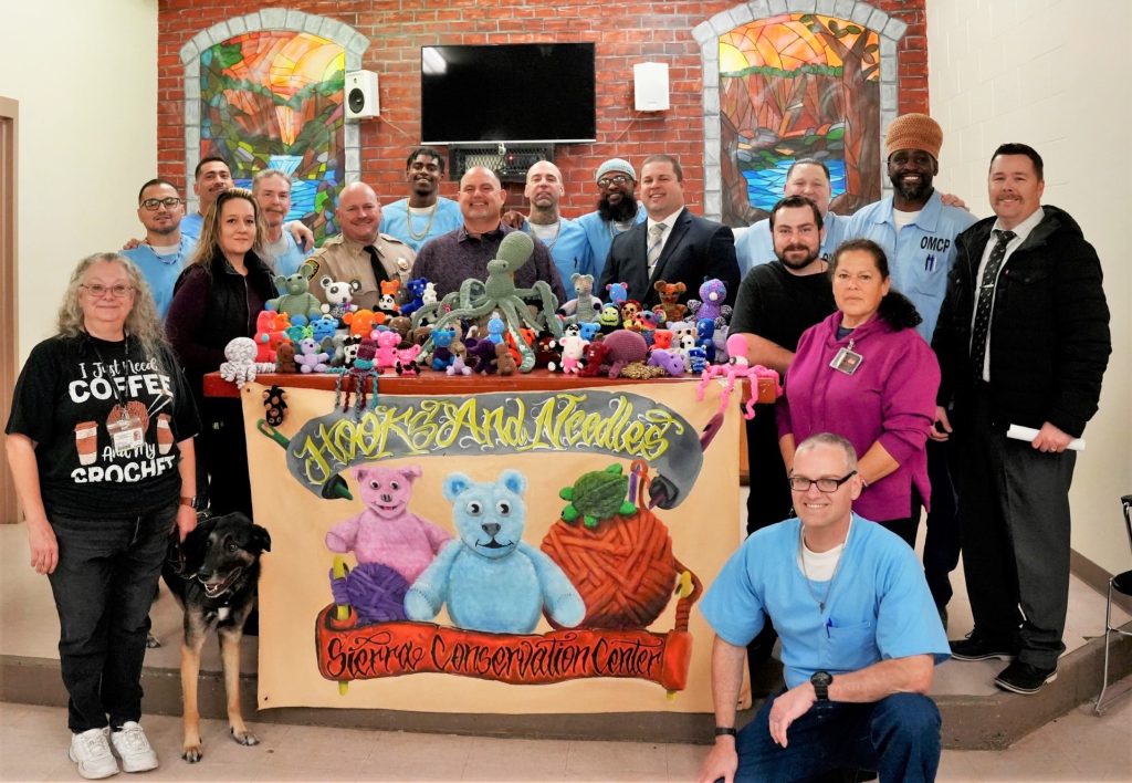 Group of incarcerated people and staff with the Hooks and Needles crochet group at SCC.