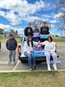 Sunrise students sitting on truck with donations from the community 