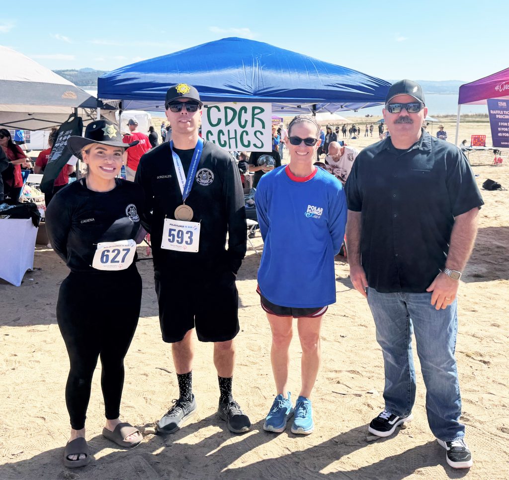 CDCR and CCHCS Freezin' for a Reason Polar Plunge team in front of a booth.