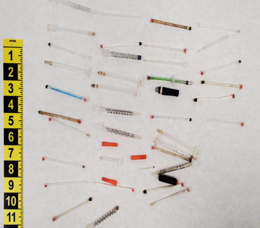 Hypodermic needles on a prison table.