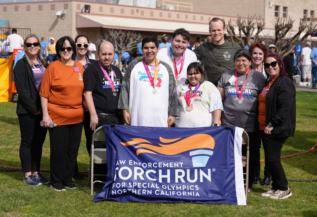 Special Olympics Torch Run banner with athletes and organizers around it at VSP.