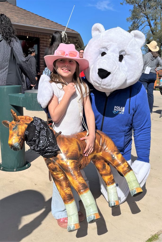 A young girl with the Polar Plunge mascot. 