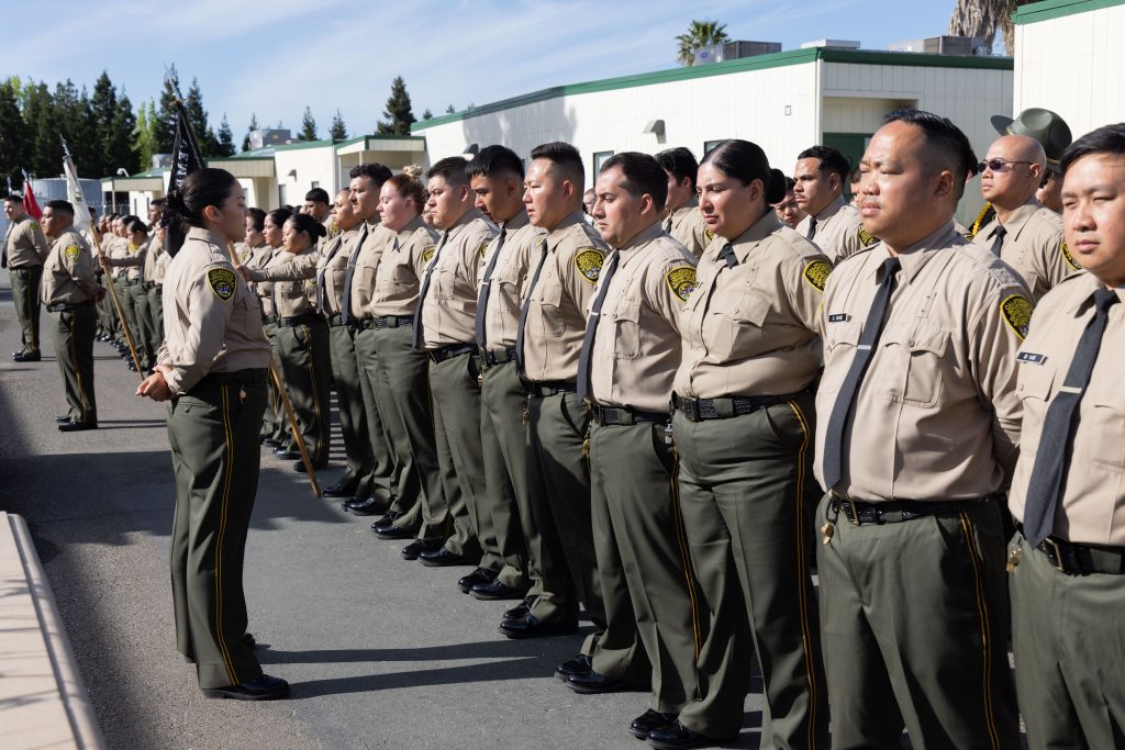 Cadets stand, waiting to march into the graduation ceremony to become the newest batch of 155 correctional officers.