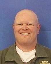 Zachary Bennett, former correctional officer, wearing his uniform and smiling.