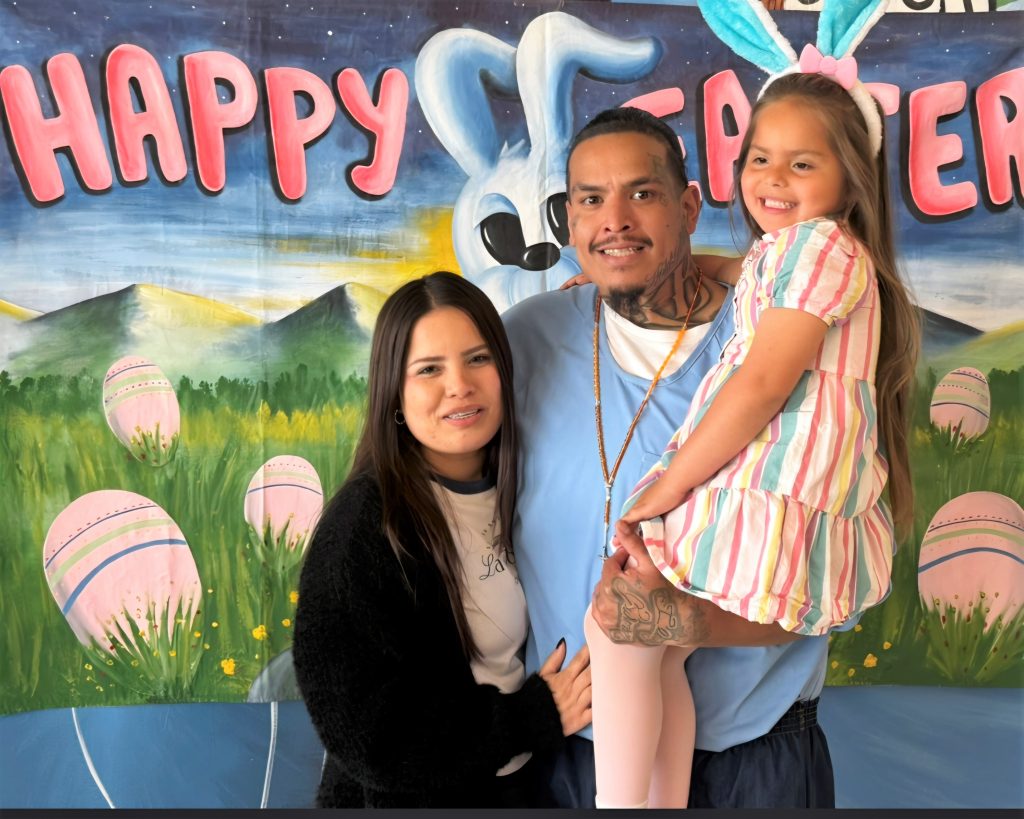 Three people with Happy Easter banner behind them at CCI.