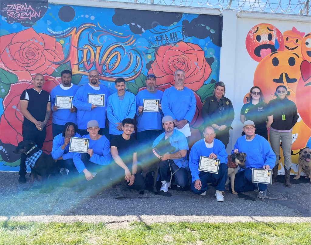 Group photo of Pawsitive Change participants and dogs at CCI.
