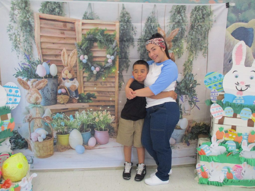 An incarcerated woman hugs a child as they pose for an Easter photo.