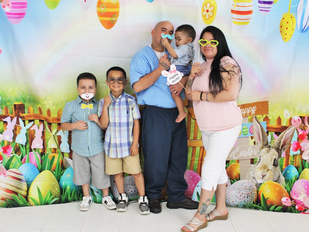 Three children and their mom pose for a family photo for Easter at CDCR-Centinela State Prison. 