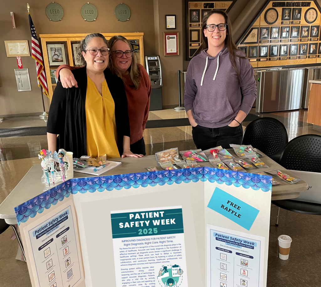 CHCF patient safety week booth with three staff members standing behind it.