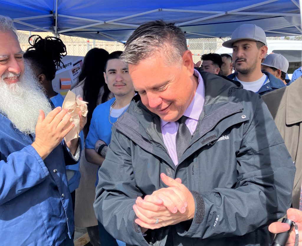 A staff members show people how to properly wash their hands.