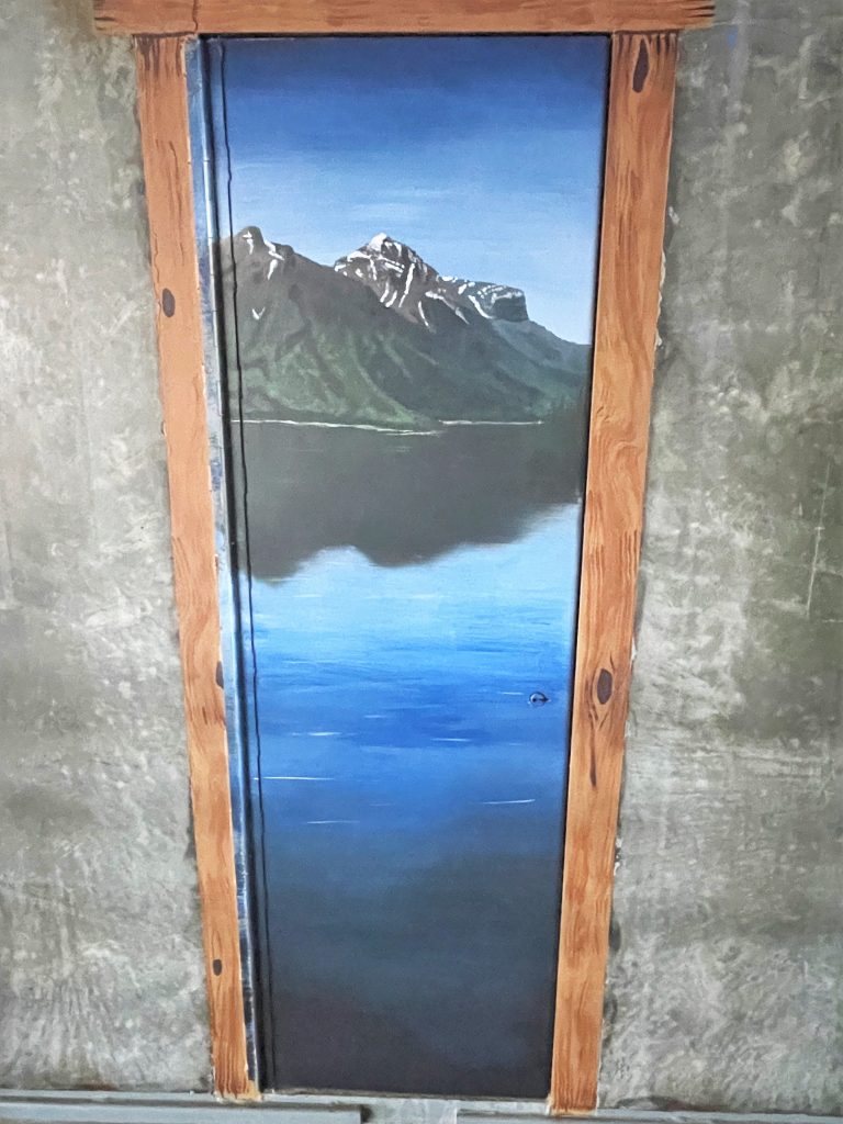 Painting of a mountain lake on a concrete prison wall in Susanville, California.