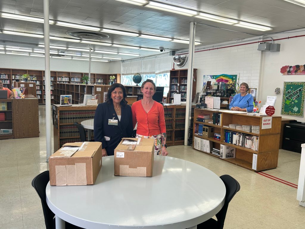 Congresswoman Norma Torres with CIW staff presenting donated books 