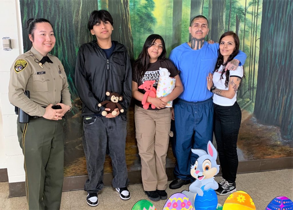 A family poses with a correctional officer for an Easter photo with their incarcerated loved one at Pelican Bay State Prison in Crescent City, Calif., April 20, 2025.