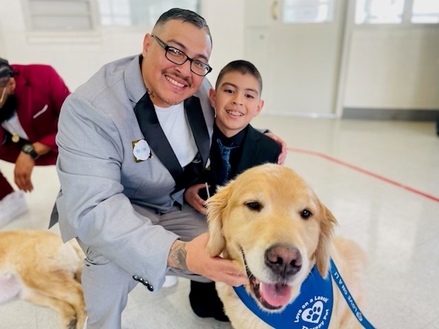 A dad, his son, and a dog at a dance at RJD.
