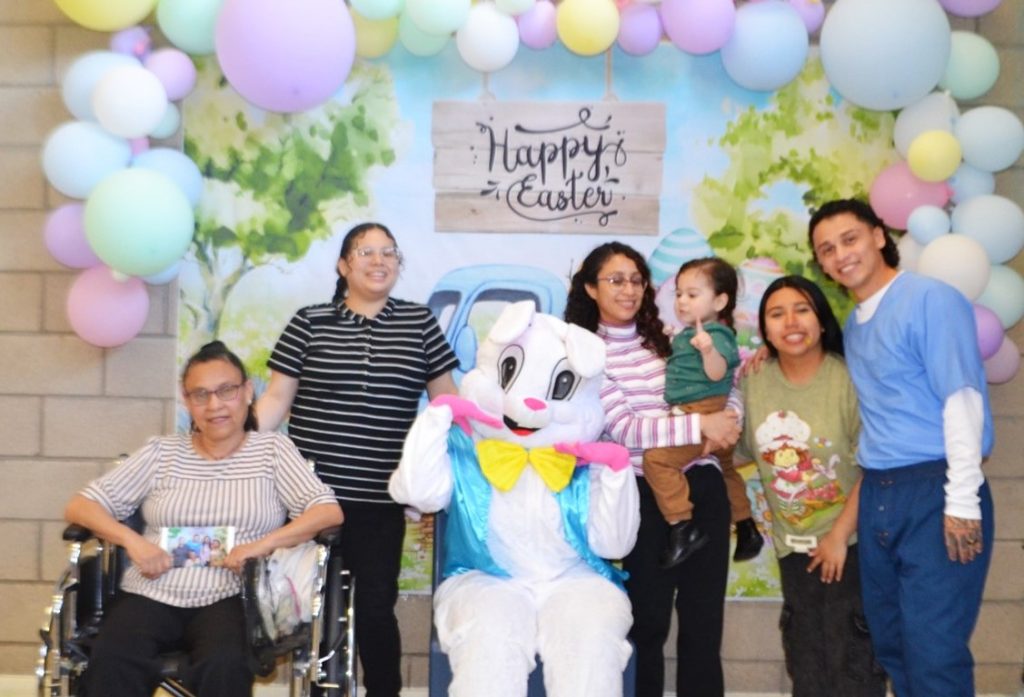 Large family posing for photos with the Easter bunny at CDCR Valley State Prison on Easter Sunday during visiting.