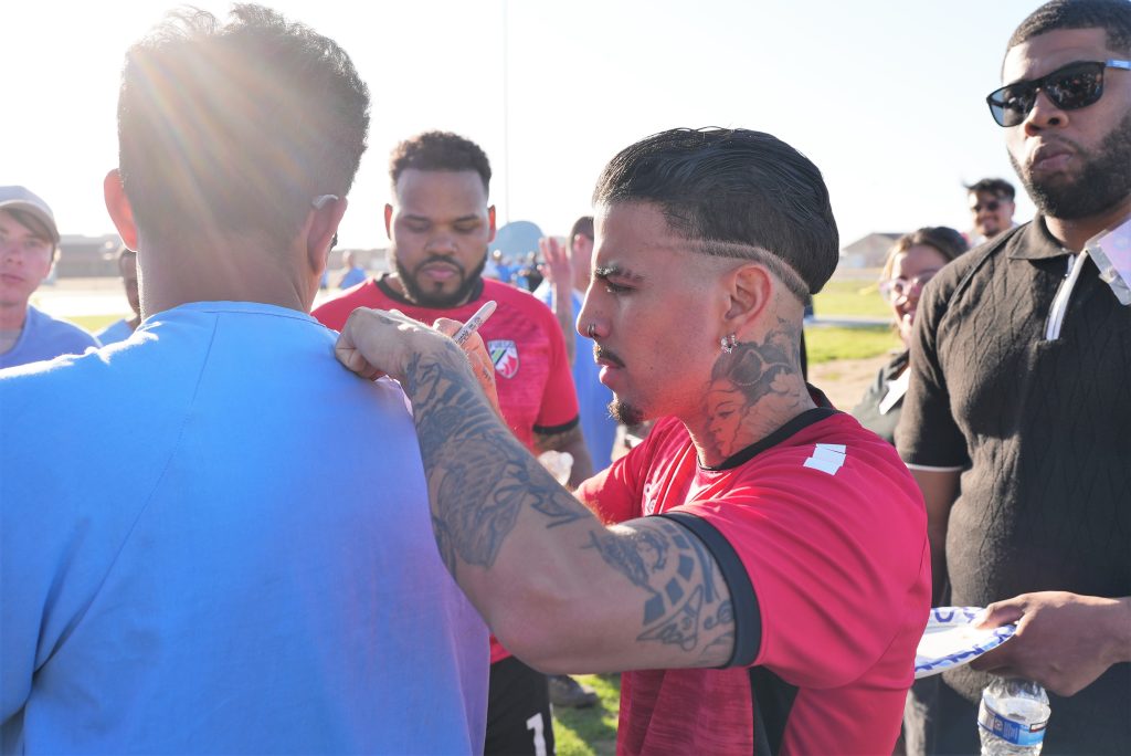 Signing autographs is Rauw Alejandro.