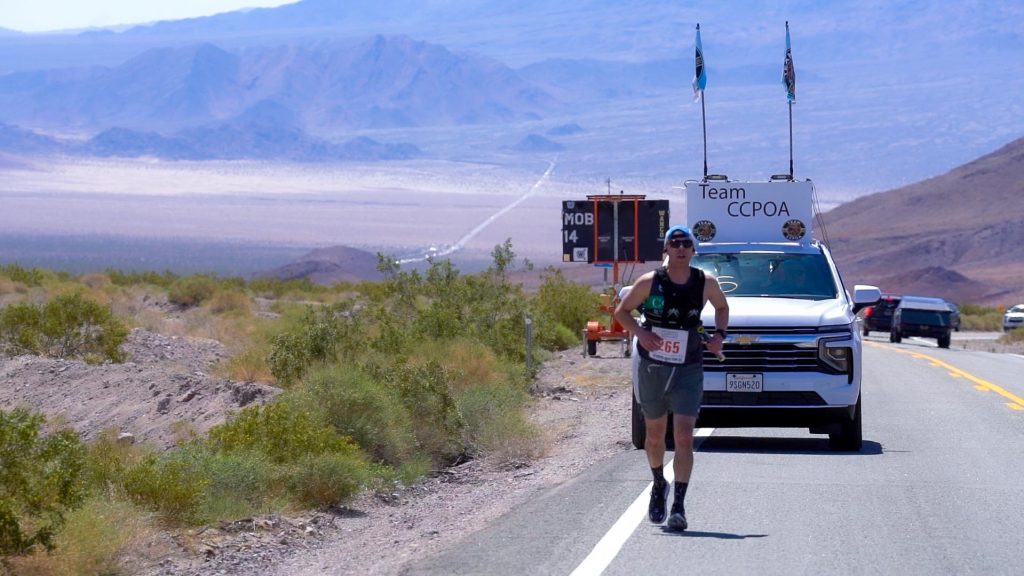 Runner in front of a follow car during a relay race.