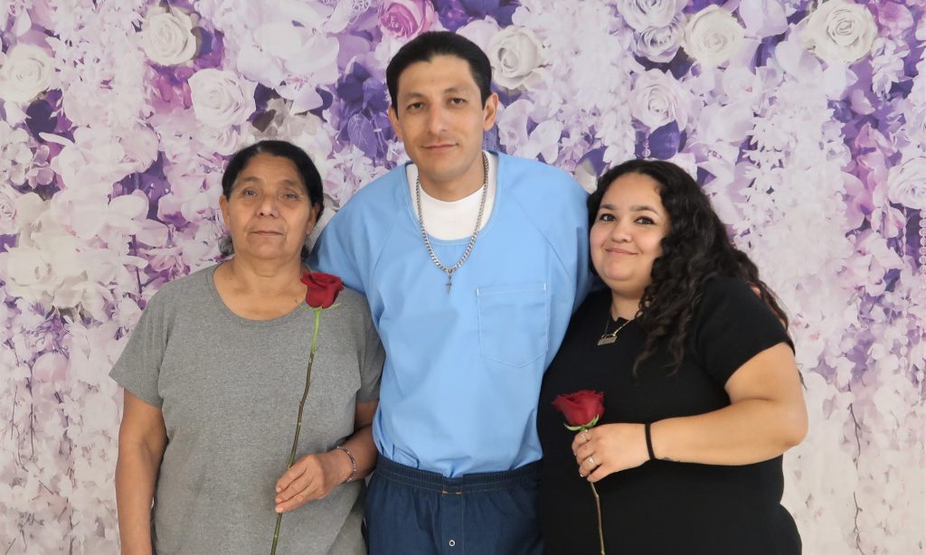 Two women hug their incarcerated loved one at CDCR Calipatria State Prison Mother's Day visiting.