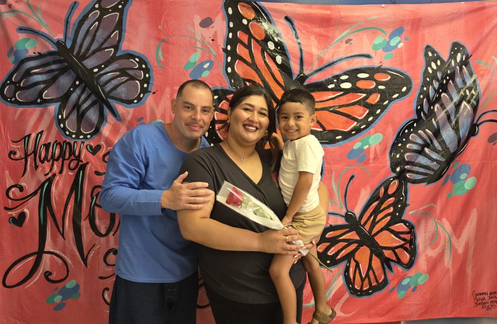 Child, woman, and incarcerated man during Mother's Day visiting at CCI-Tehachapi.