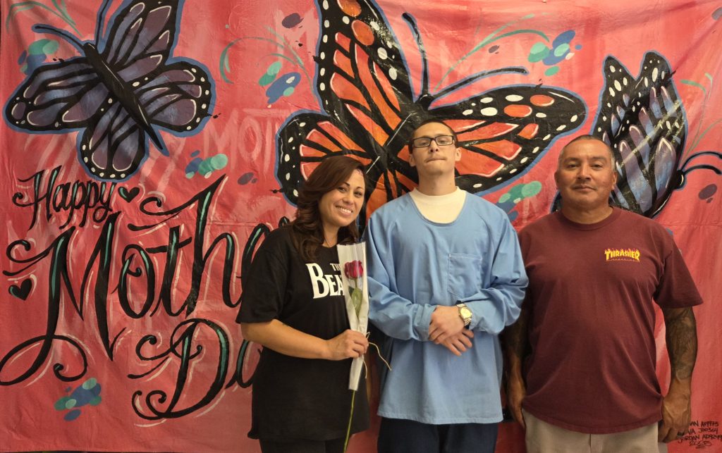 Two people and in incarcerated person at CCI-Tehachapi for Mother's Day visiting.