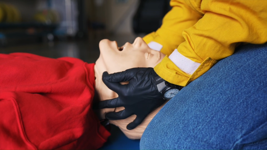 Demonstrating a head tilt, chin lift to make sure the airway is clear.