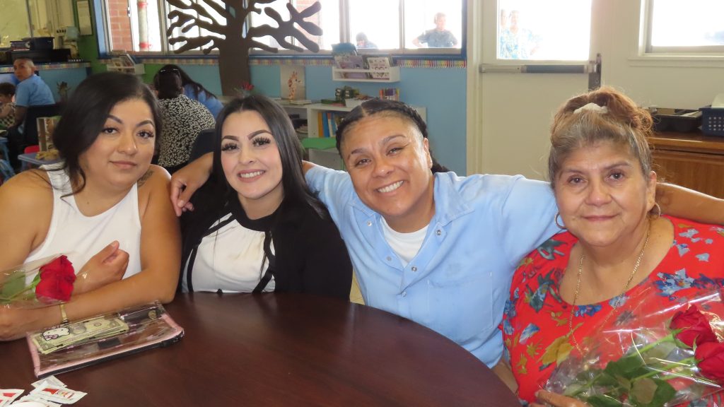 Family members smile as they visit their incarcerated loved one at California Institution for Women during Mother's Day visiting in May 2025 at Corona, California.