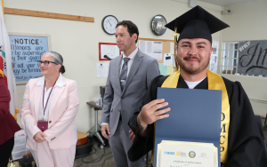 A proud graduate holds his certification at CMC.