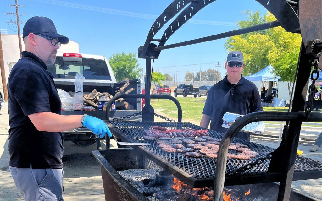 People barbecue hamburgers and hot dogs as part of a staff appreciation event at CSP-Corcoran.