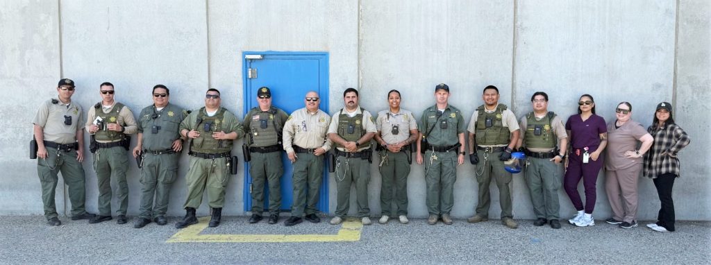 Staff line up against a wall at CSP-Corcoran.