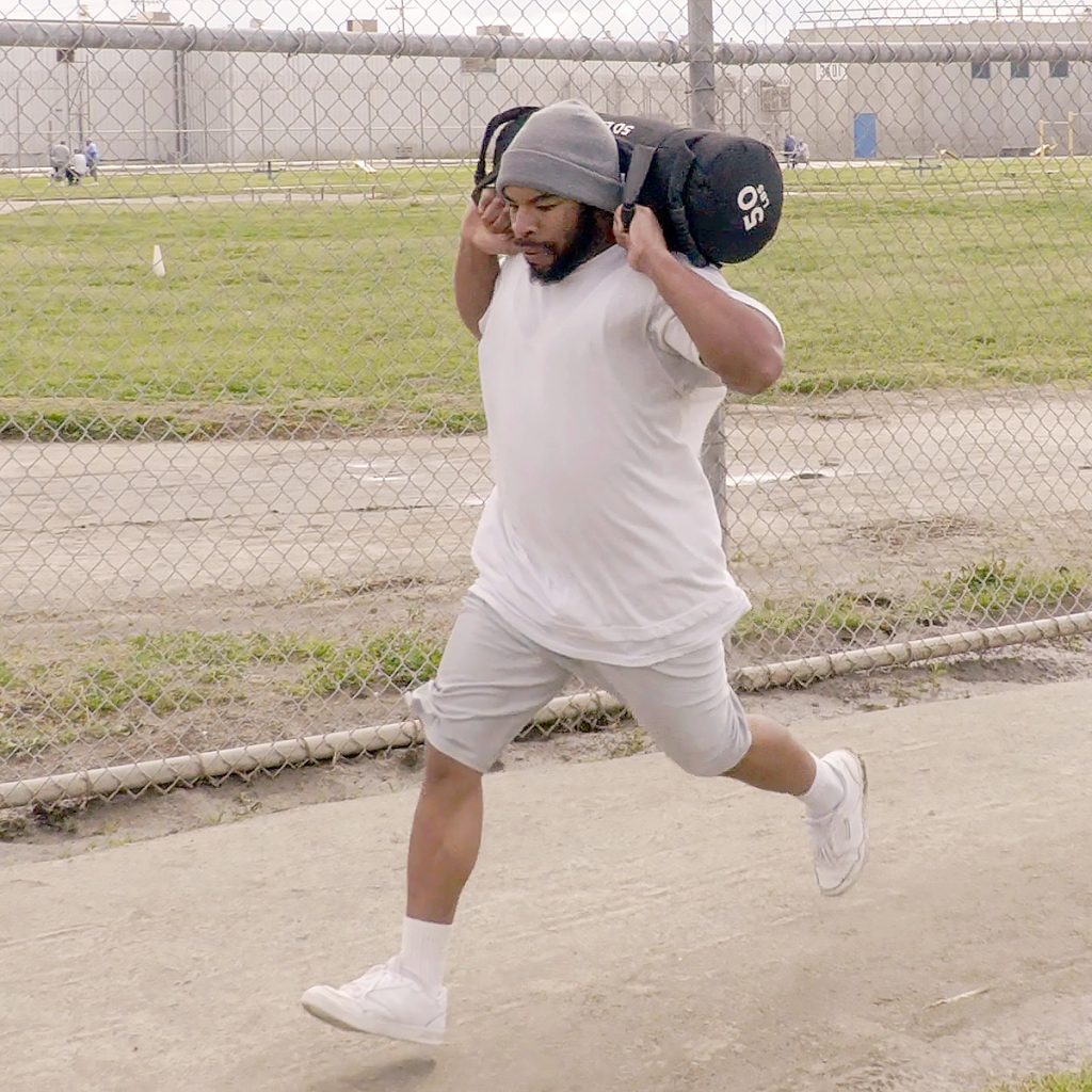 Incarcerated person running with weights