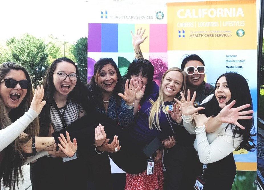 Staff pose for photos against a public service appreciation and recognition banner at headquarters in Elk Grove, California, May 2025.