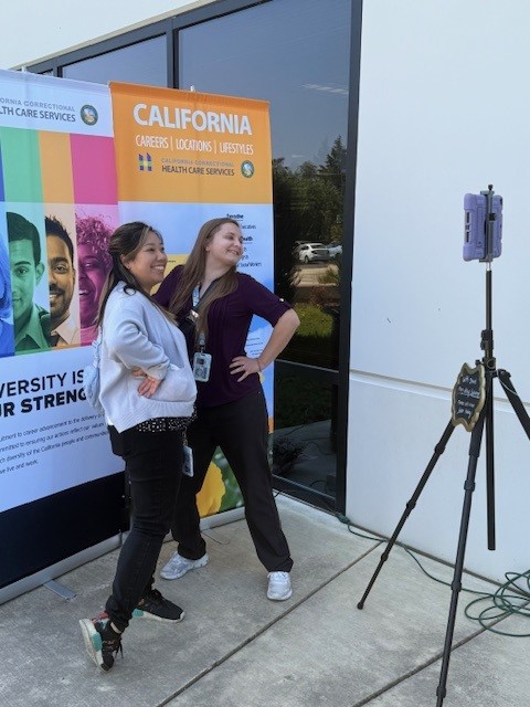 Two people posing for photos during employee appreciation event at CDCR, CCHCS headquarters in Elk Grove, California.