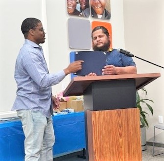 Taran Downing receives an award from Habitat for Humanity.