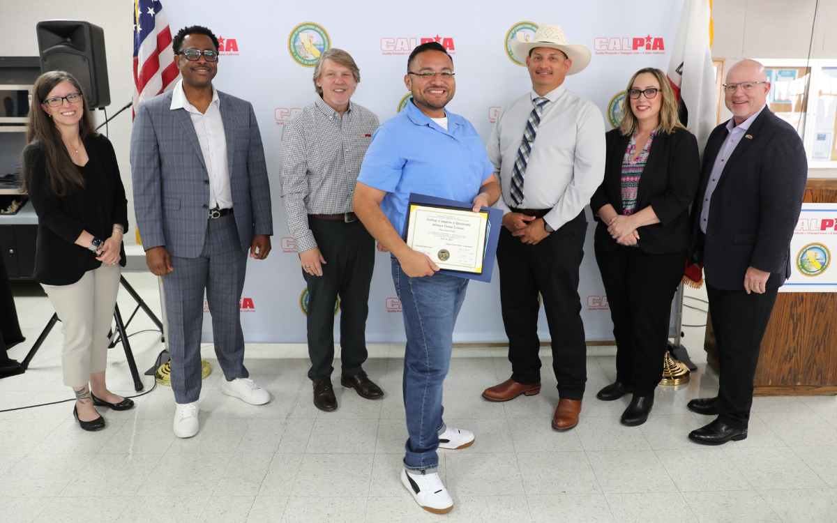 CALPIA staff and the RJD prison warden with one of the graduates earning certification May 6.
