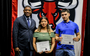 Valley State Prison warden and two high school students holding their scholarships.