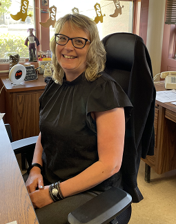 Missy sitting at her desk, smiling