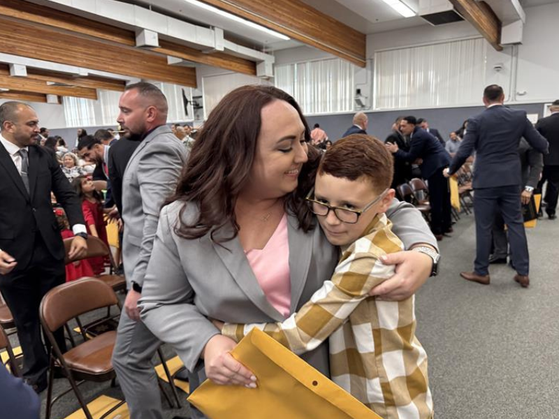 A child hugs their new parole agent family member.
